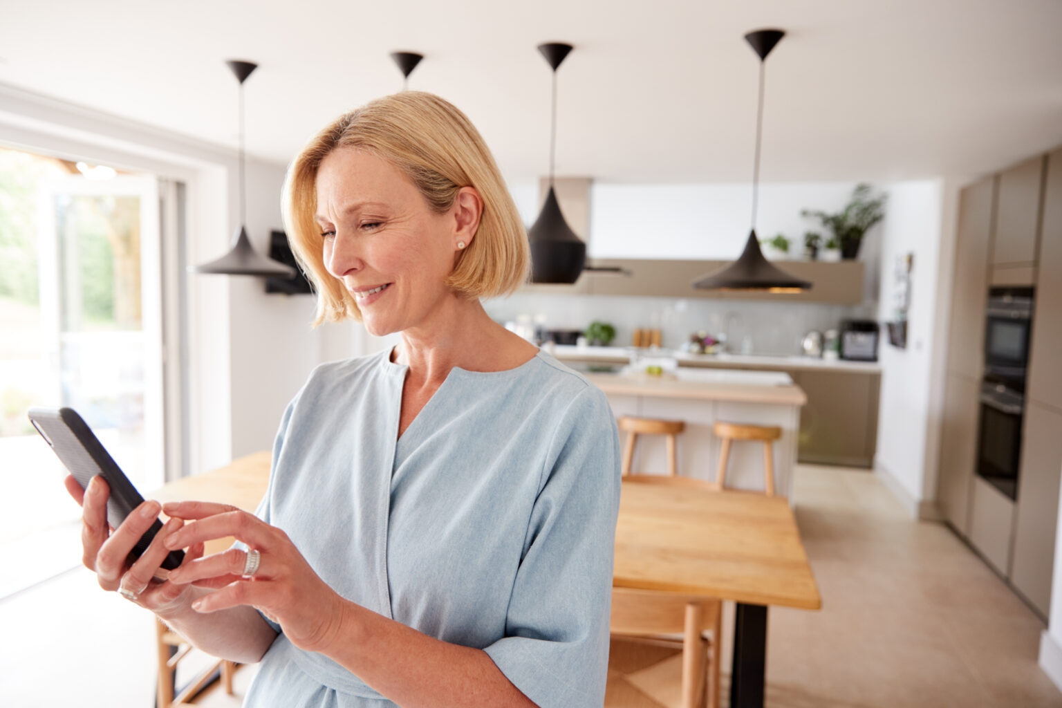 Woman checking her phone in a modern kitchen